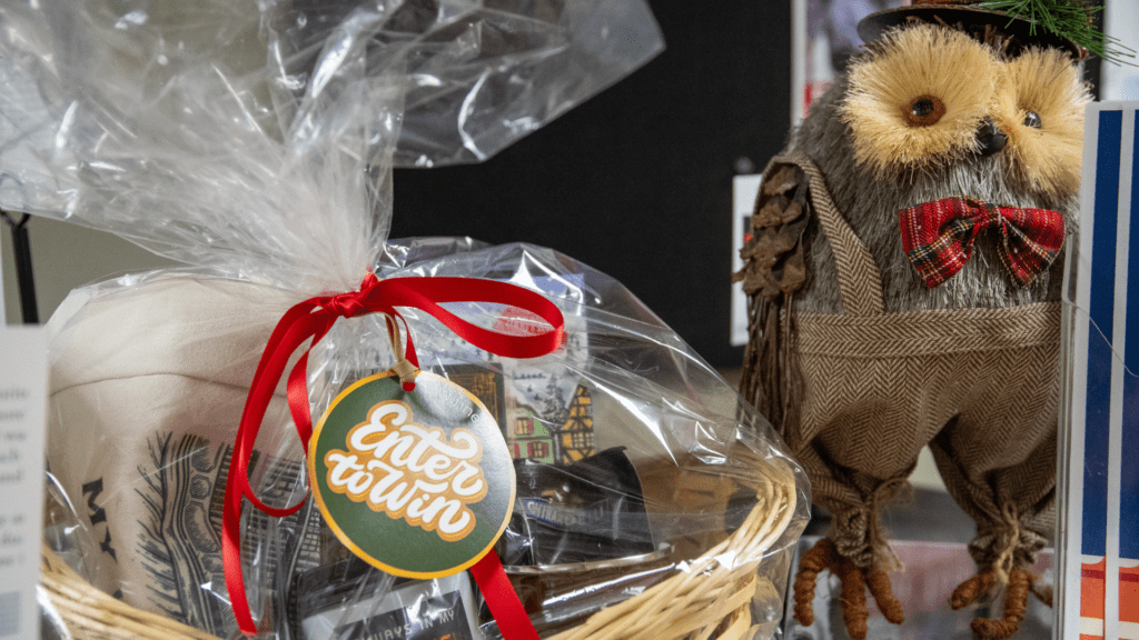 Image shows a gift basket with an owl behind it.